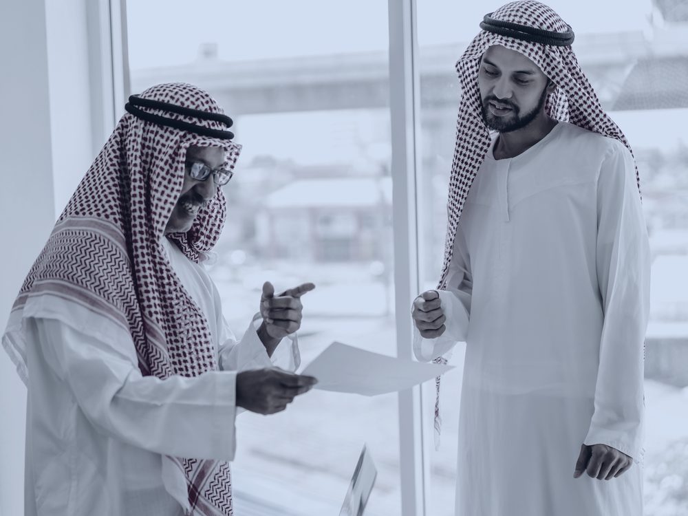 A senior executive reviewing a document with an investor in a boardroom.