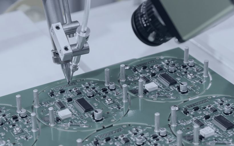Automated soldering head placing components on a circuit board.